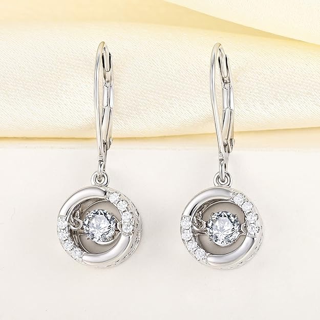 Silver earrings with clear gemstones on a light background