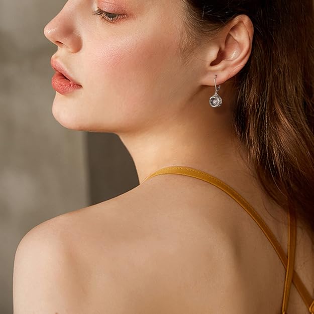 Close-up of a woman wearing a yellow top with thin straps, focusing on her ear and earring.