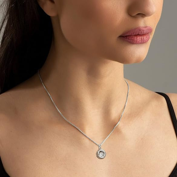 Close-up of a woman wearing a black top with thin straps, focusing on her neckline and necklace.