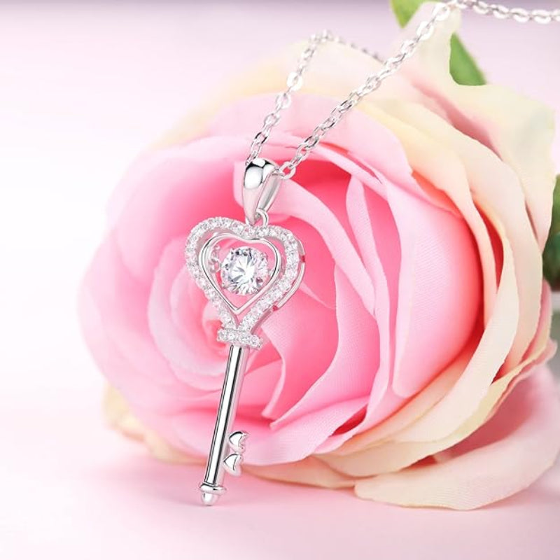 Silver heart-shaped key pendant on a pink rose